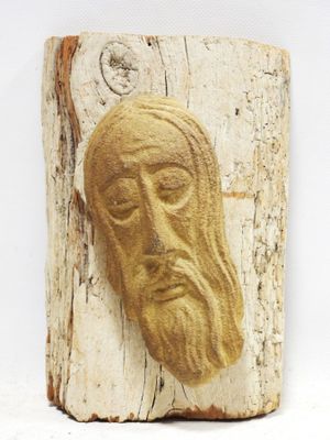 wooden carving of a man ' s face on a piece of wood