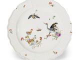 un gros plan d'une assiette décorée d'oiseaux et de fleurs