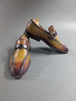 pair of men ' s hand painted shoes on a grey surface