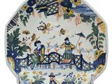 une assiette sur laquelle est représenté un couple sur un pont