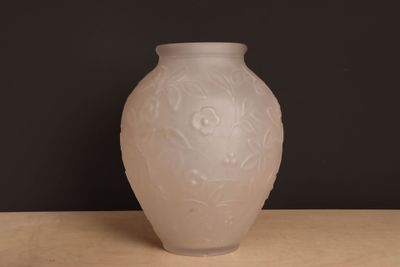 un vase blanc posé sur une table sur fond noir