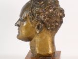 bronze head of a man with curly hair on a wooden base