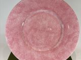 a pink plate sitting on top of a wooden stand