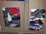 a cardboard box with clothes on top of it in a warehouse