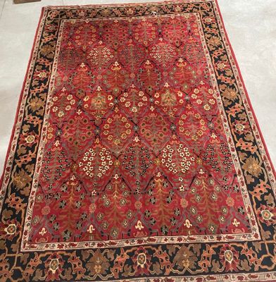 a red rug with a black border on a white floor