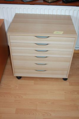 a wooden dresser with three drawers on it in a room