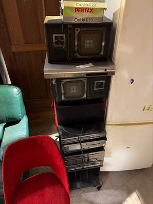 a stack of microwaves sitting on top of a stack of chairs