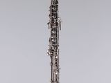 a clarinet with a silver body and black keys on a clear stand