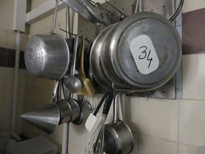 de nombreuses casseroles et poêles accrochées au mur