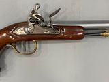un gros plan d'un pistolet accroché au mur, sur fond blanc