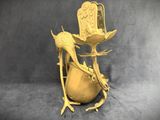 a gold vase with two birds on it on a gray background