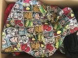 une boîte contenant une couverture sur laquelle sont représentées de nombreuses bandes dessinées différentes