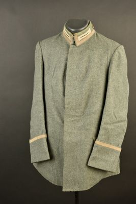 an old coat with a collar and cuffs on a mannequin stand