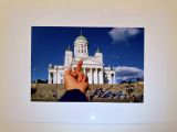 a picture of a person holding a finger up in front of a building