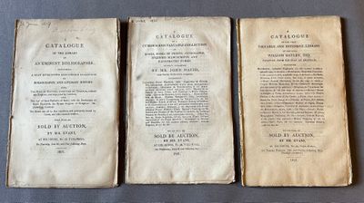 trois vieux livres posés sur une table l'un à côté de l'autre