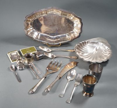 a silver plate with silverware and silver spoons on a table
