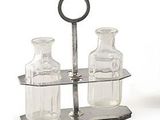 three glass bottles and a metal holder on a white surface