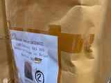a cardboard bag with a sticker on it sitting on the ground