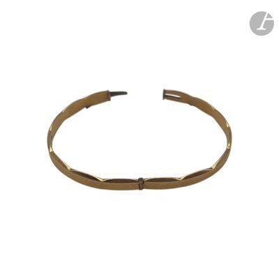 gros plan d'un bracelet en or sur fond blanc