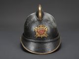 an old fireman ' s helmet with a gold emblem on it