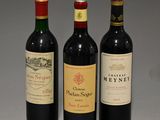 trois bouteilles de vin posées l'une à côté de l'autre sur une table