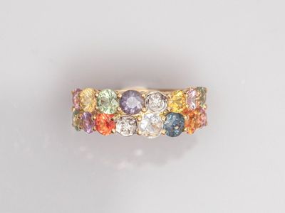 gros plan d'une bague en or avec des pierres multicolores