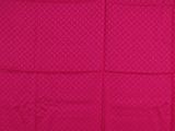 the pink blanket is folded on top of the bed