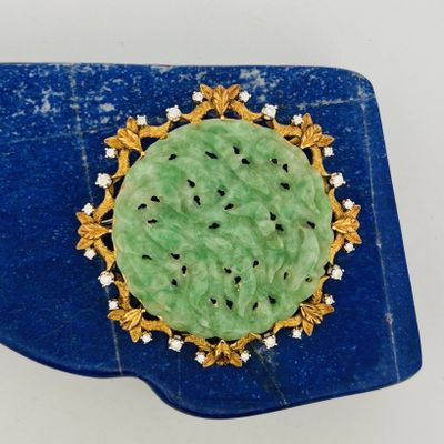 green jade and diamond broochle on a blue tray