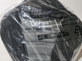 un objet noir enveloppé dans du plastique posé sur une surface blanche