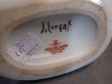 a close up of a white vase with a tag on it