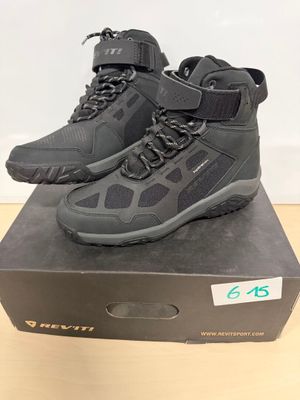 une paire de chaussures de randonnée noires posée sur une boîte