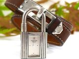 a silver padlock on a brown leather bracelet