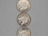 three silver coins sitting on top of each other on a table