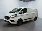 La camionnette blanche est garée dans une grande pièce.