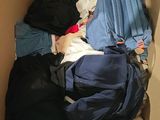 a cardboard box filled with clothes and a backpack