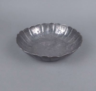 une assiette ancienne en argent, ornée d'un motif floral sur le bord