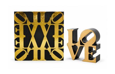 two gold and black love sculptures next to each other on a white surface