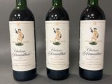 trois bouteilles de vin rouge posées sur une table