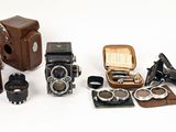 a lot of different types of old cameras on the table