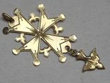 a gold pendant with a bird and a star on it