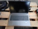 a laptop computer sitting on a pallet on a table