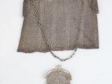 un petit sac à main ancien en maille d'argent muni d'une chaîne, auquel est suspendu un autre petit sac à main en argent muni d'une chaîne
