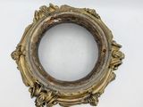 an old gold frame with a flower decoration on it