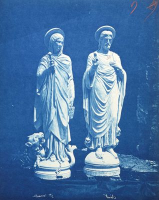 une vieille photo représentant deux statues de Jésus et de Marie sur un socle
