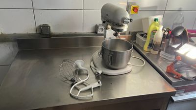a mixer on the counter in the kitchen with a whisk attachment