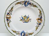 une assiette blanche ornée d'un motif bleu et jaune