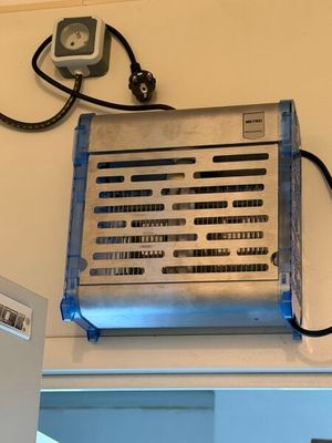 un climatiseur argenté et bleu fixé au mur