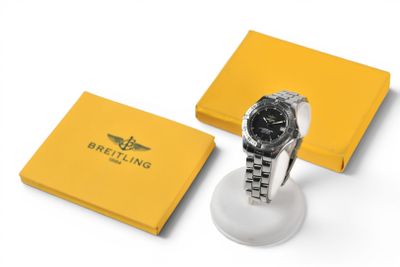 une montre noire et blanche posée sur une boîte jaune