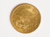 a close up of a gold coin on a white surface