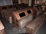 several wooden benches are lined up in a room with wooden walls